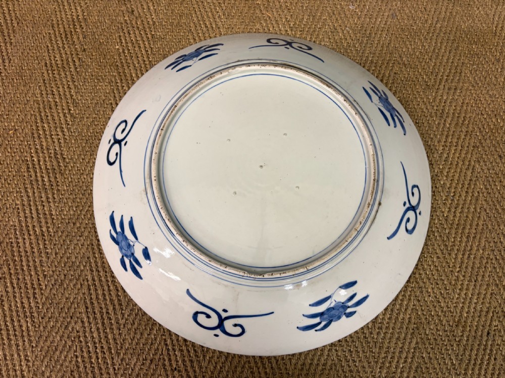 A circular 19th-century Japanese Imari porcelain charger decorated in cobalt blue, iron red, and gilt with paneled bird and floral motifs around a central vase design. View VI