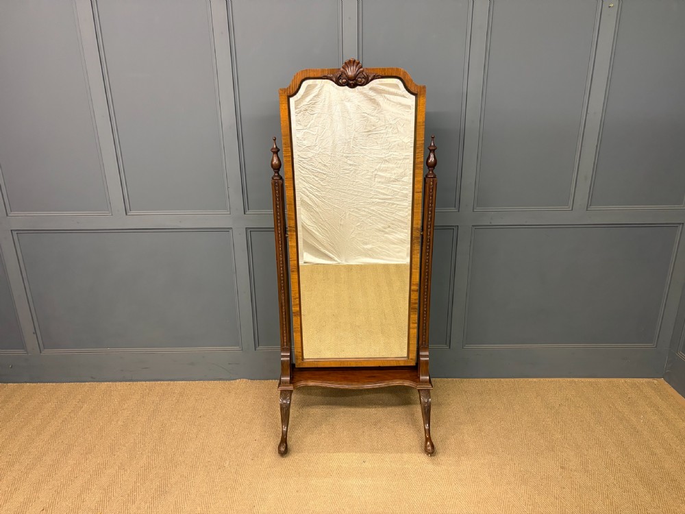 A Queen Anne style walnut cheval mirror with an arched frame, carved shell motif, finial posts, and cabriole legs. View II