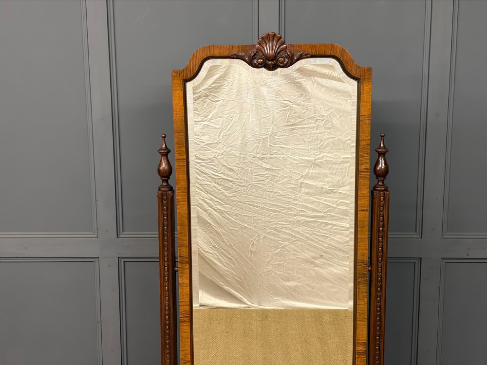 A Queen Anne style walnut cheval mirror with an arched frame, carved shell motif, finial posts, and cabriole legs. View III