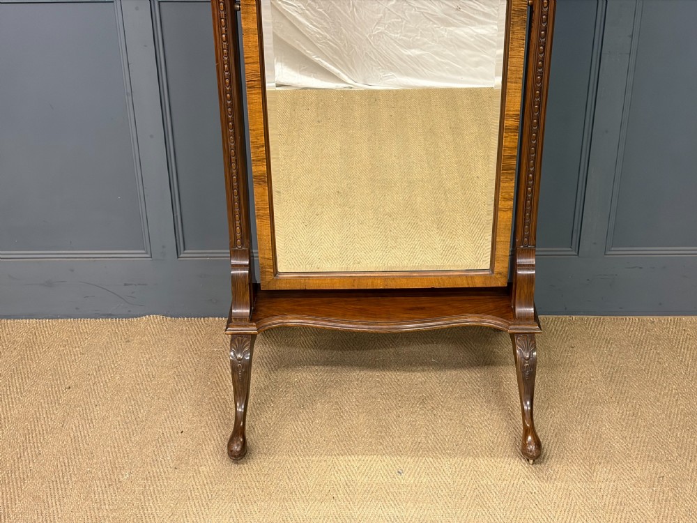 A Queen Anne style walnut cheval mirror with an arched frame, carved shell motif, finial posts, and cabriole legs. View IV