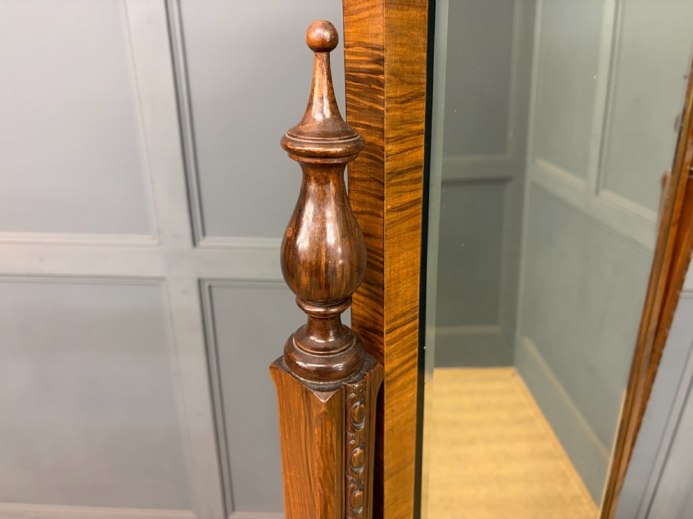 A Queen Anne style walnut cheval mirror with an arched frame, carved shell motif, finial posts, and cabriole legs. View VII