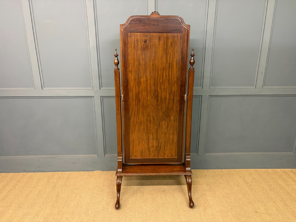 A Queen Anne style walnut cheval mirror with an arched frame, carved shell motif, finial posts, and cabriole legs. View XIII