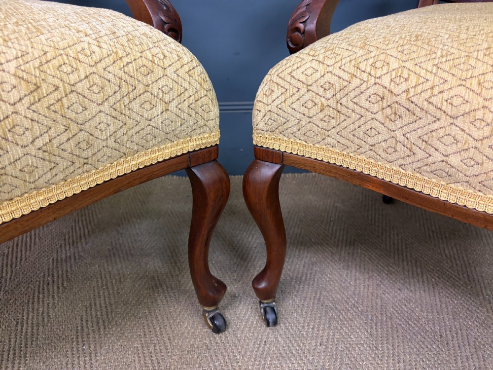 A seven-piece Victorian mahogany salon suite comprising a carved settee, two armchairs, and four side chairs, all upholstered in yellow patterned fabric. View XII