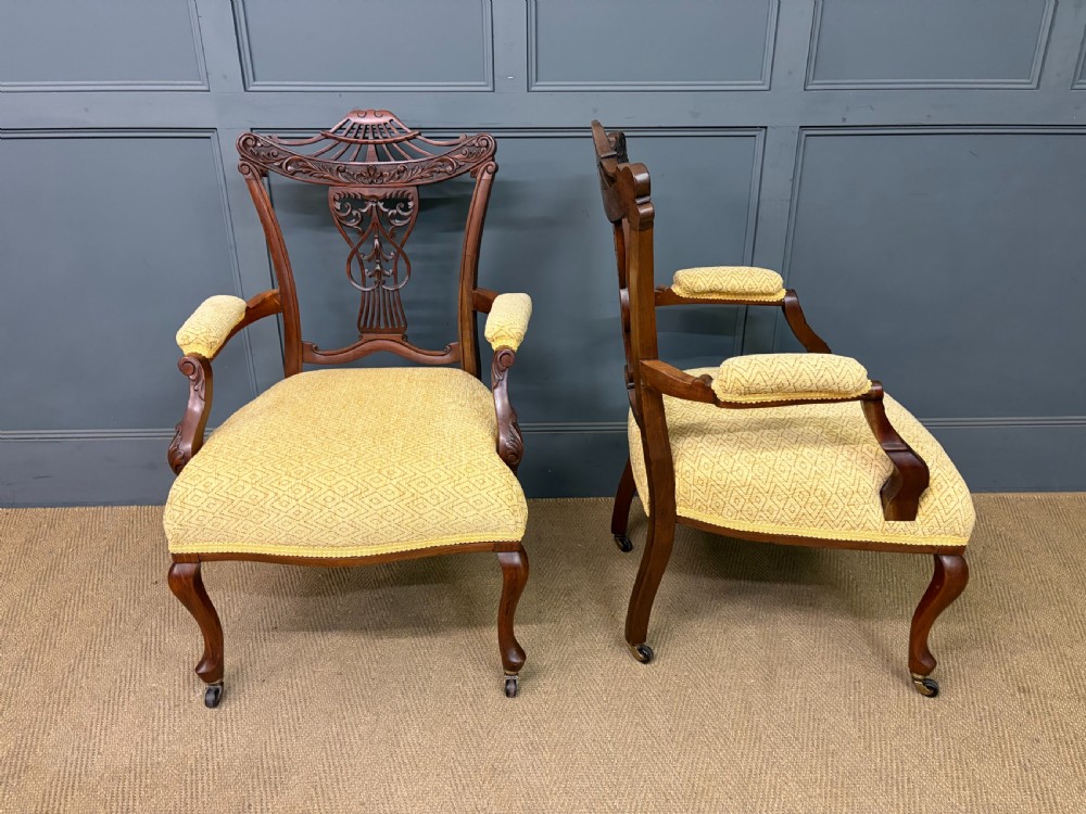 A seven-piece Victorian mahogany salon suite comprising a carved settee, two armchairs, and four side chairs, all upholstered in yellow patterned fabric. View XIII