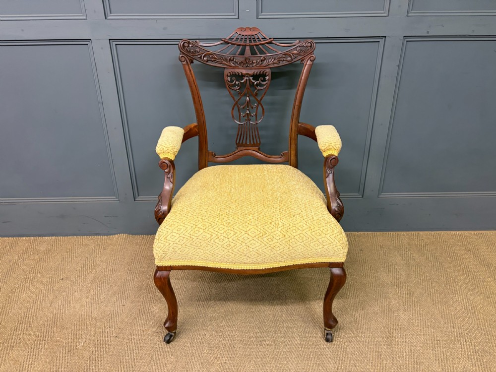 A seven-piece Victorian mahogany salon suite comprising a carved settee, two armchairs, and four side chairs, all upholstered in yellow patterned fabric. View XV