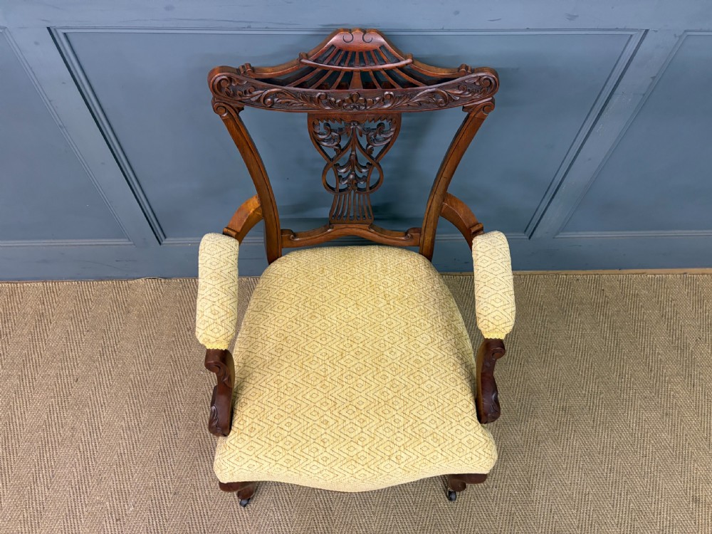 A seven-piece Victorian mahogany salon suite comprising a carved settee, two armchairs, and four side chairs, all upholstered in yellow patterned fabric. View XVII