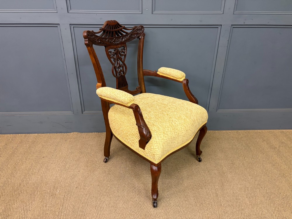 A seven-piece Victorian mahogany salon suite comprising a carved settee, two armchairs, and four side chairs, all upholstered in yellow patterned fabric. View XIX