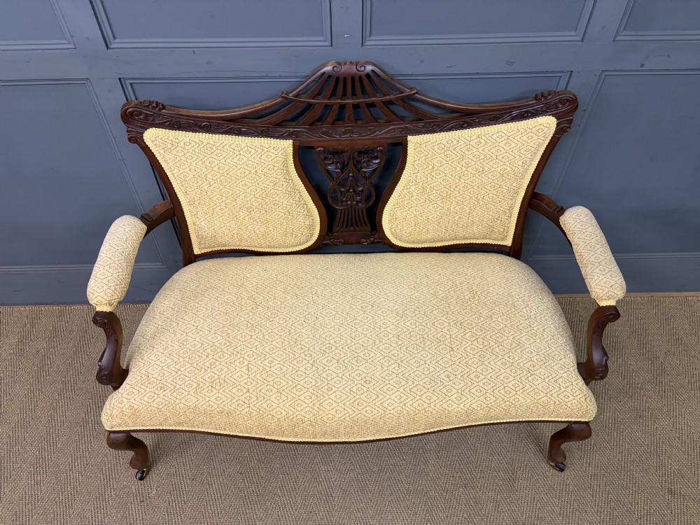 A seven-piece Victorian mahogany salon suite comprising a carved settee, two armchairs, and four side chairs, all upholstered in yellow patterned fabric. View XXII