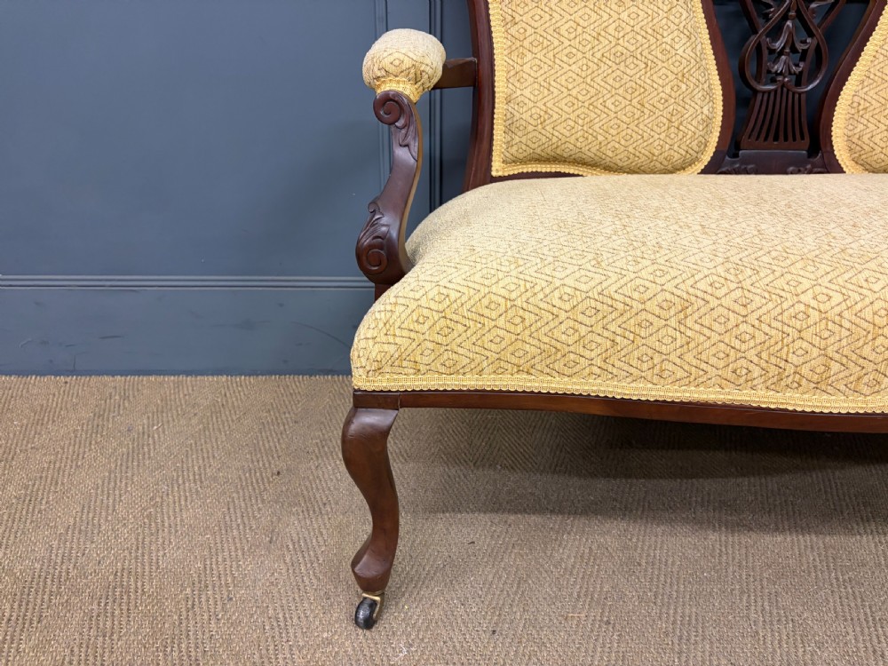 A seven-piece Victorian mahogany salon suite comprising a carved settee, two armchairs, and four side chairs, all upholstered in yellow patterned fabric. View XXV
