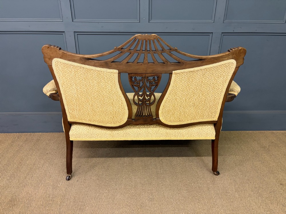 A seven-piece Victorian mahogany salon suite comprising a carved settee, two armchairs, and four side chairs, all upholstered in yellow patterned fabric. View XXVIII