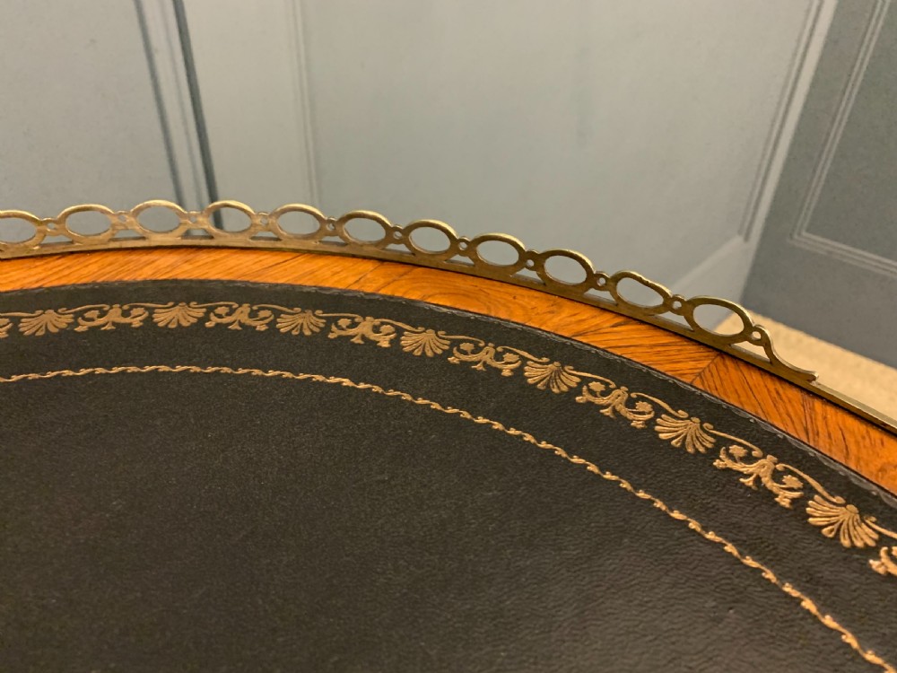 A Victorian kidney-shaped rosewood writing table featuring a dark leather top with gilt tooling, a pierced brass gallery, and cabriole legs with decorative ormolu mounts. View IV
