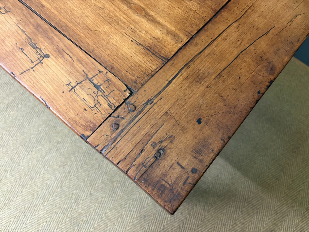 An early 19th-century fruitwood refectory table with a plank top, single side drawer, and stretcher base. View VIII