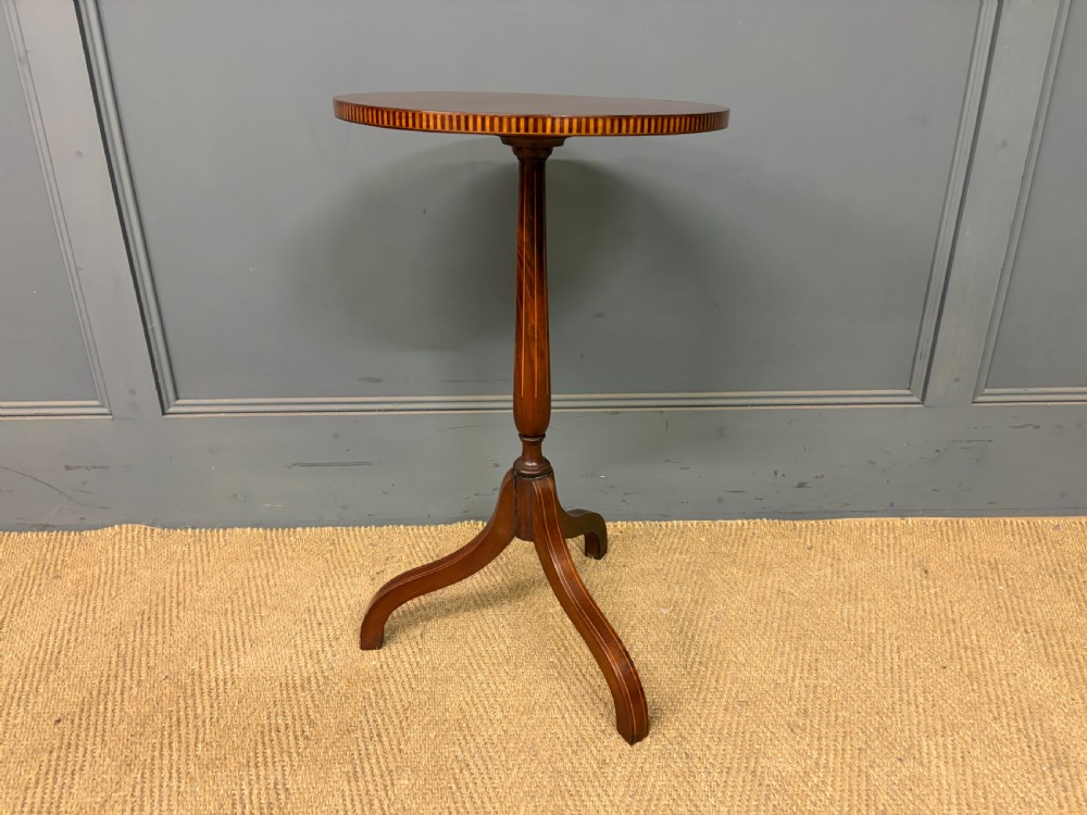 An Edwardian mahogany wine table featuring a circular top with satinwood inlay, a turned central column, and a tripod base. View II