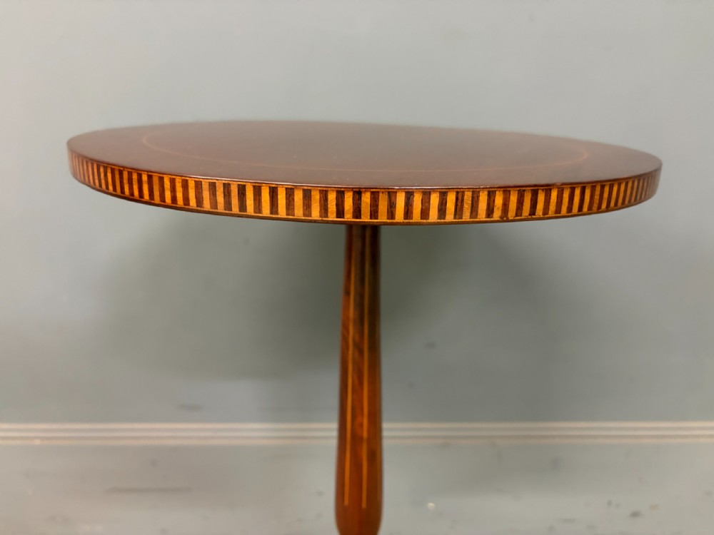 An Edwardian mahogany wine table featuring a circular top with satinwood inlay, a turned central column, and a tripod base. View III