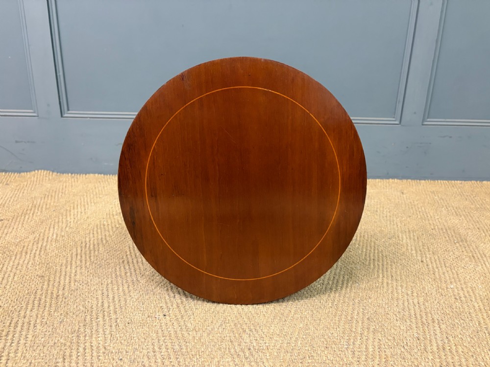 An Edwardian mahogany wine table featuring a circular top with satinwood inlay, a turned central column, and a tripod base. View V