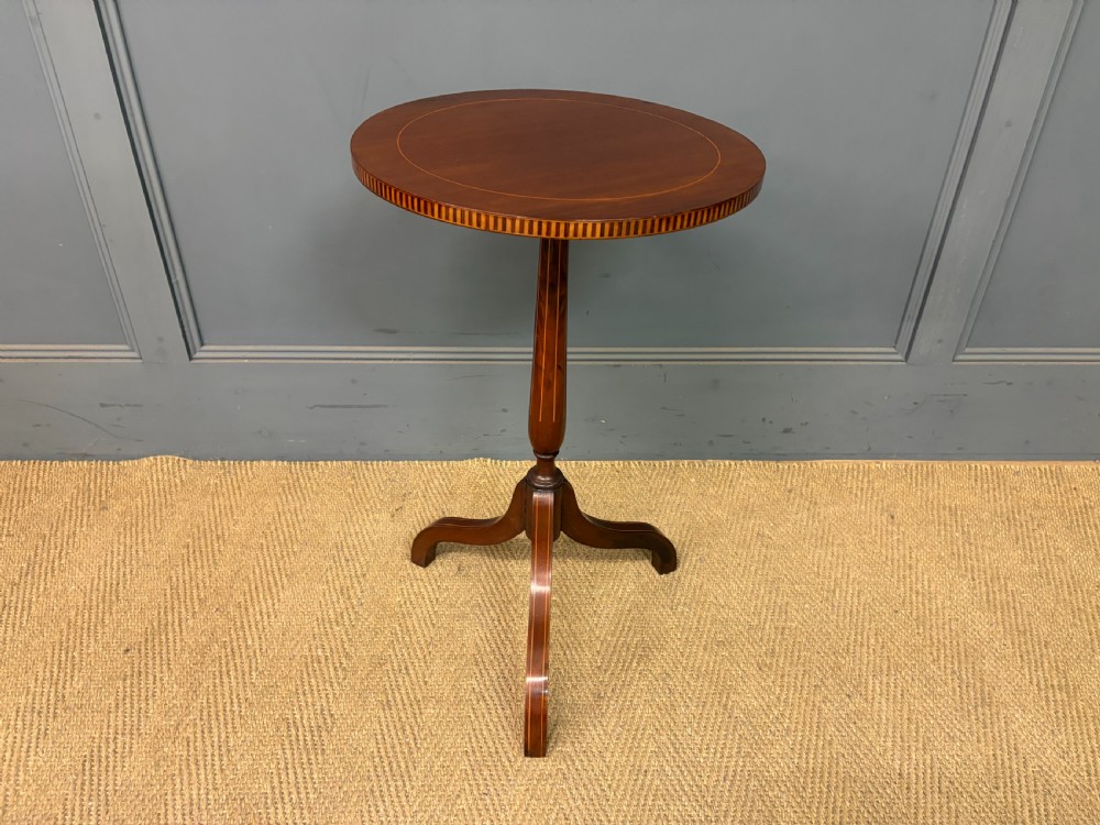 An Edwardian mahogany wine table featuring a circular top with satinwood inlay, a turned central column, and a tripod base. View VI