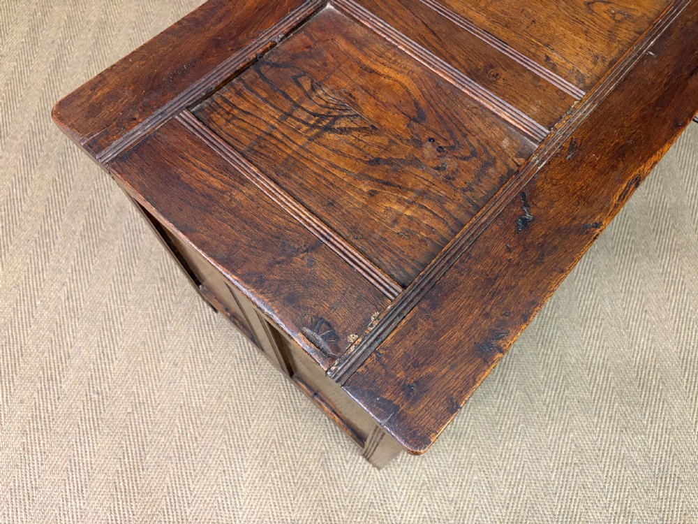A Georgian oak coffer featuring a three-panel front framing, a hinged top, and a brass keyhole escutcheon. View XVI