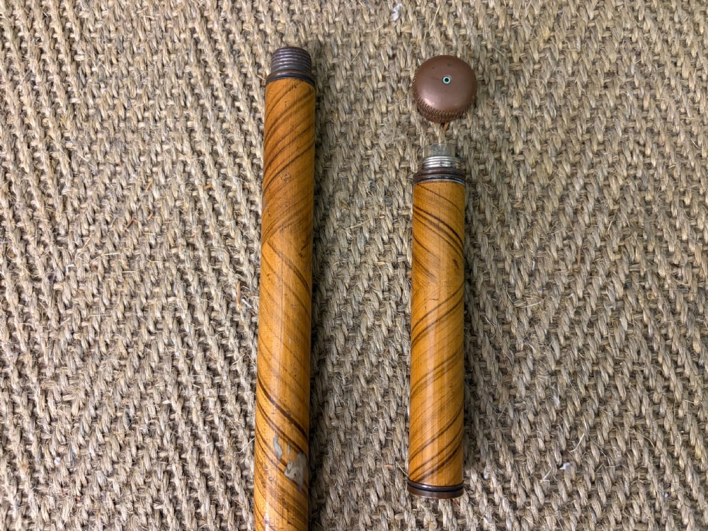 A Victorian wooden walking cane featuring a spiral pattern along the tapered shaft and a metal collar. View VI