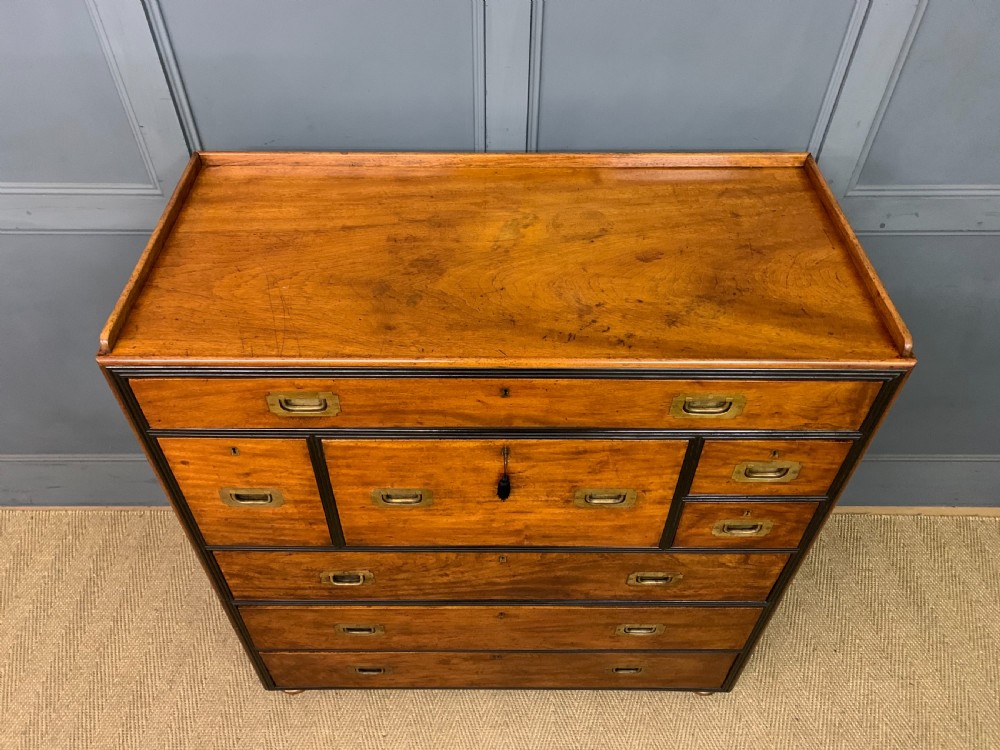 A nineteenth-century camphor wood military campaign chest with dark wood borders, flush brass handles, and a central drop-front secretaire section. View III