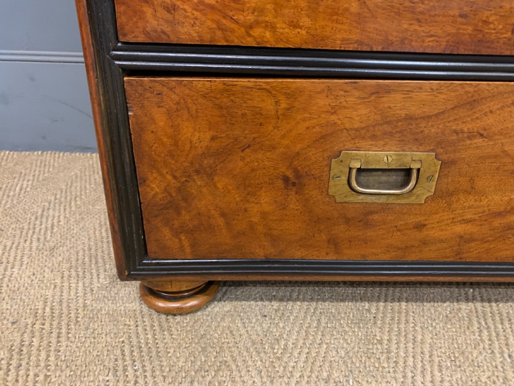 A nineteenth-century camphor wood military campaign chest with dark wood borders, flush brass handles, and a central drop-front secretaire section. View VII