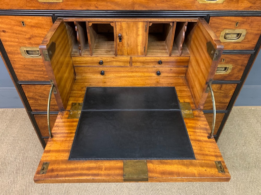 A nineteenth-century camphor wood military campaign chest with dark wood borders, flush brass handles, and a central drop-front secretaire section. View XI