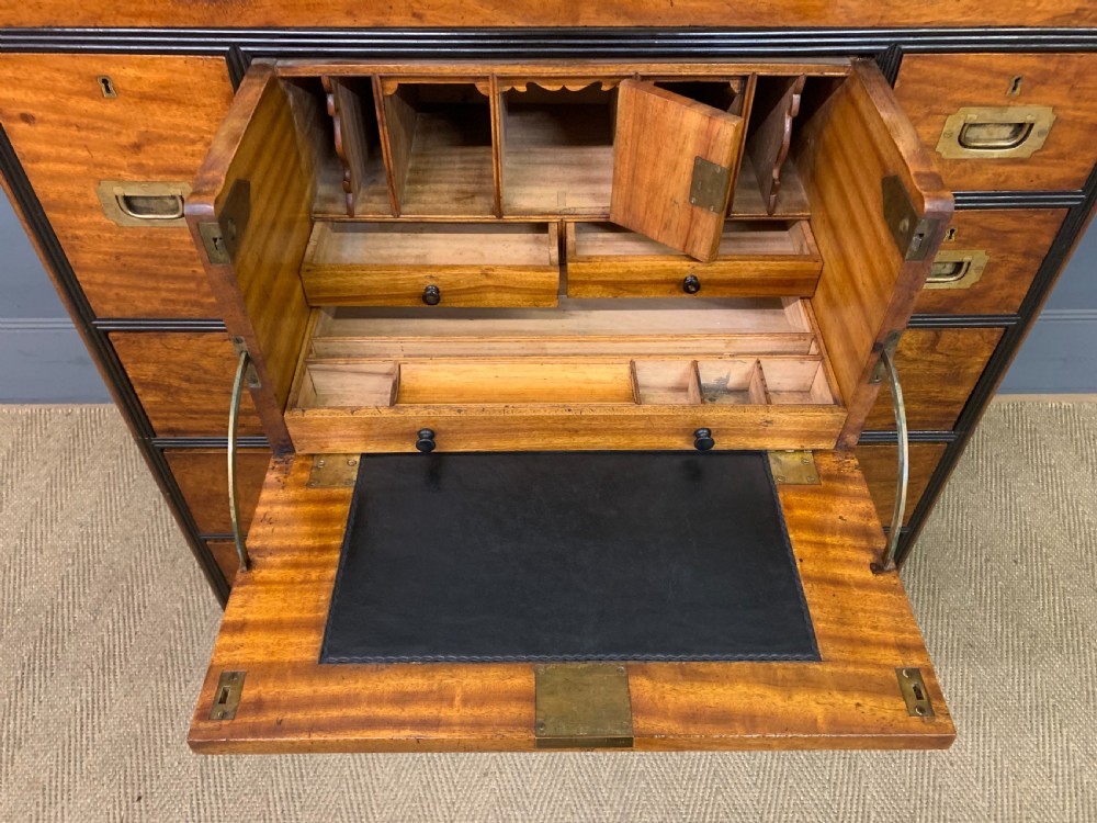 A nineteenth-century camphor wood military campaign chest with dark wood borders, flush brass handles, and a central drop-front secretaire section. View XII