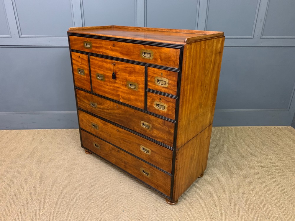 A nineteenth-century camphor wood military campaign chest with dark wood borders, flush brass handles, and a central drop-front secretaire section. View XIII