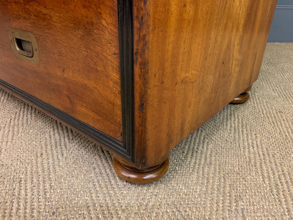 A nineteenth-century camphor wood military campaign chest with dark wood borders, flush brass handles, and a central drop-front secretaire section. View XIV