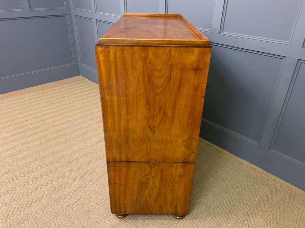 A nineteenth-century camphor wood military campaign chest with dark wood borders, flush brass handles, and a central drop-front secretaire section. View XV