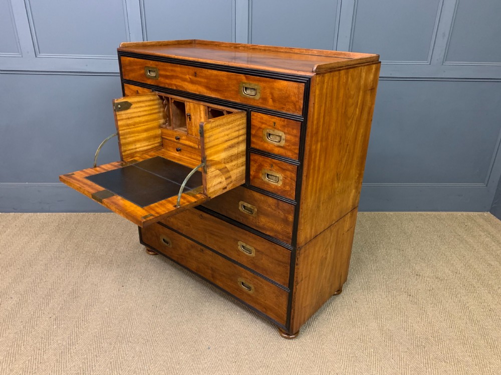 A nineteenth-century camphor wood military campaign chest with dark wood borders, flush brass handles, and a central drop-front secretaire section. View XVI