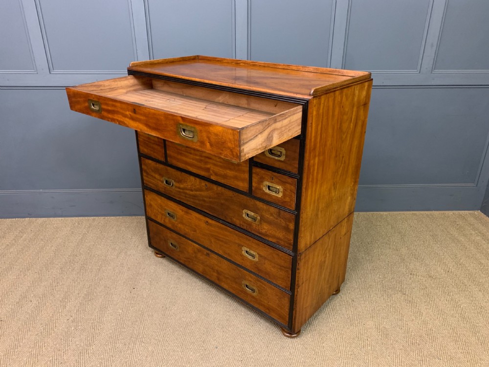 A nineteenth-century camphor wood military campaign chest with dark wood borders, flush brass handles, and a central drop-front secretaire section. View XXI