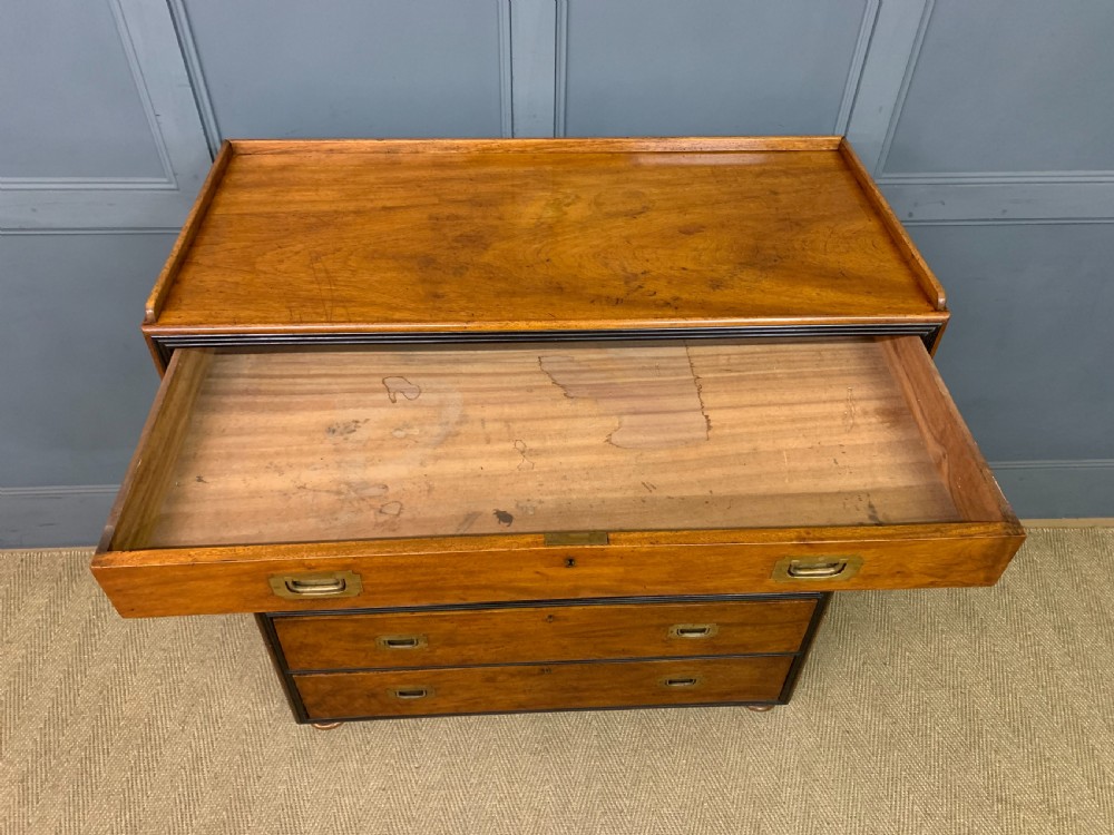 A nineteenth-century camphor wood military campaign chest with dark wood borders, flush brass handles, and a central drop-front secretaire section. View XXII
