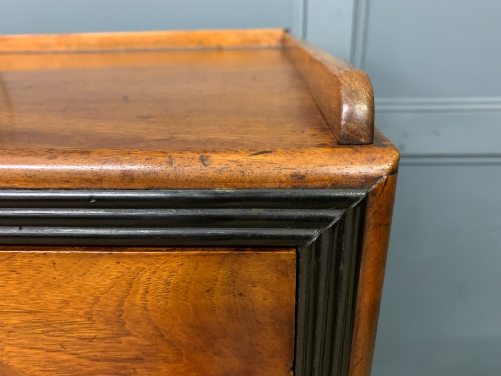 A nineteenth-century camphor wood military campaign chest with dark wood borders, flush brass handles, and a central drop-front secretaire section. View XXIII