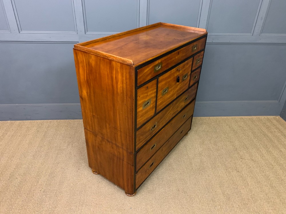 A nineteenth-century camphor wood military campaign chest with dark wood borders, flush brass handles, and a central drop-front secretaire section. View XXIV