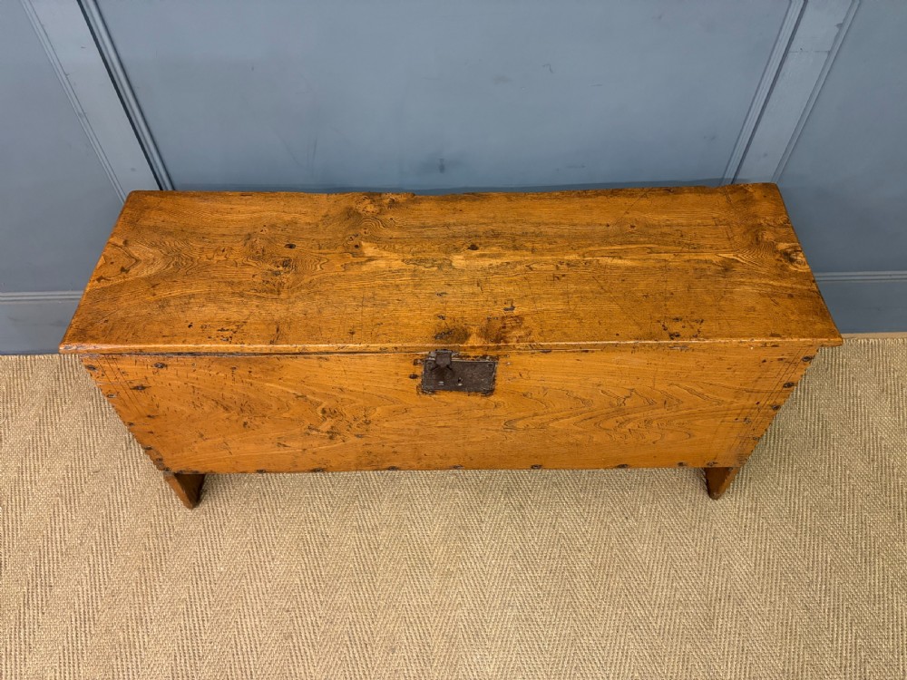 An 18th-century elm coffer featuring a rectangular hinged lid, prominent wood grain, central iron lockplate, and slab ends. View III