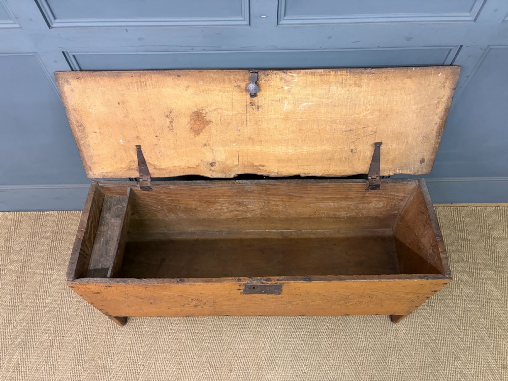 An 18th-century elm coffer featuring a rectangular hinged lid, prominent wood grain, central iron lockplate, and slab ends. View V
