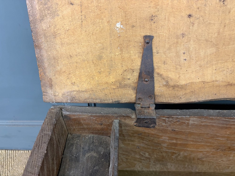 An 18th-century elm coffer featuring a rectangular hinged lid, prominent wood grain, central iron lockplate, and slab ends. View VI