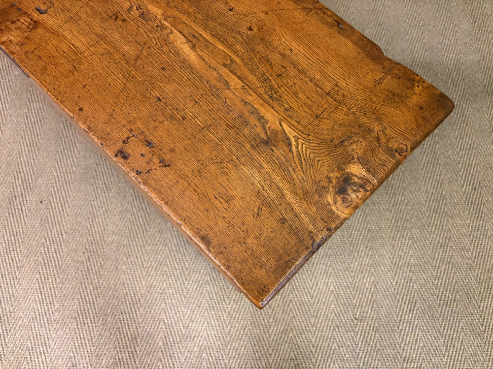 An 18th-century elm coffer featuring a rectangular hinged lid, prominent wood grain, central iron lockplate, and slab ends. View XII