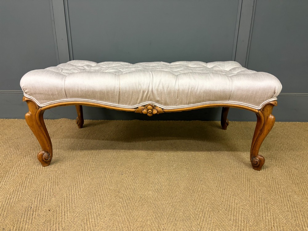 A large rectangular Victorian rosewood stool with deep-buttoned cream upholstery and carved cabriole legs. View VI