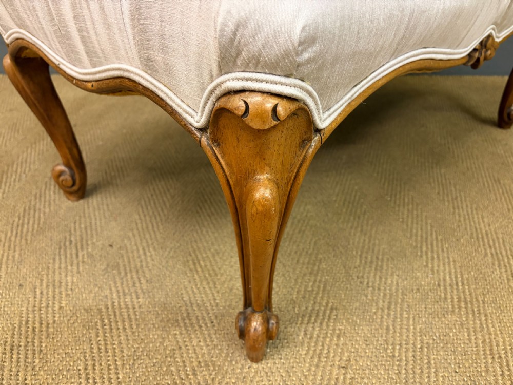 A large rectangular Victorian rosewood stool with deep-buttoned cream upholstery and carved cabriole legs. View IX