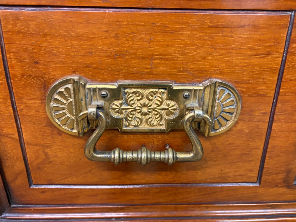 A large Victorian walnut secretaire bookcase featuring three upper glazed doors with arched panels over a central carved writing drawer and lower carved cupboard doors. View VII