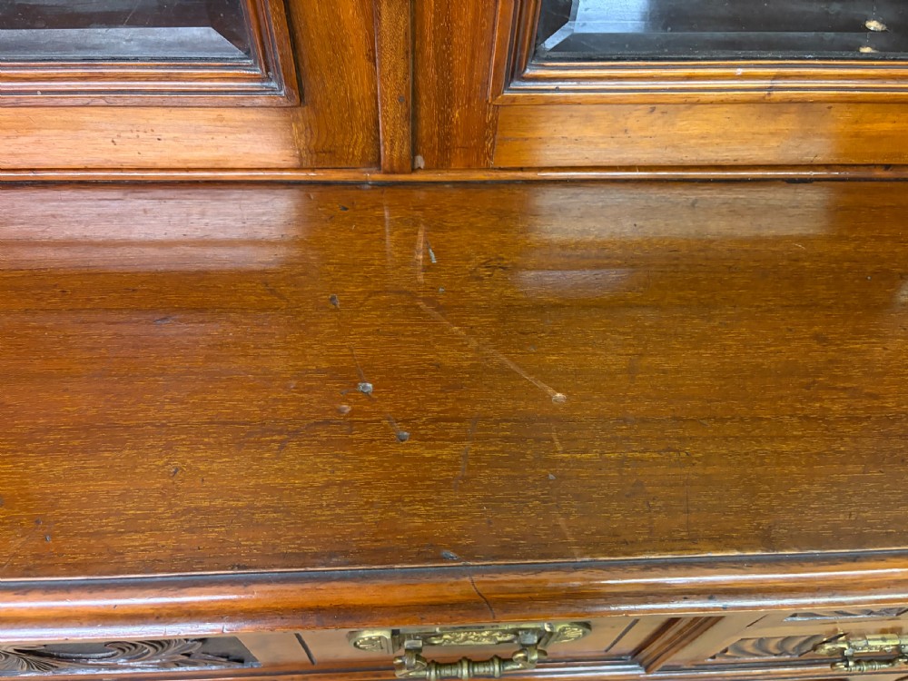 A large Victorian walnut secretaire bookcase featuring three upper glazed doors with arched panels over a central carved writing drawer and lower carved cupboard doors. View XI