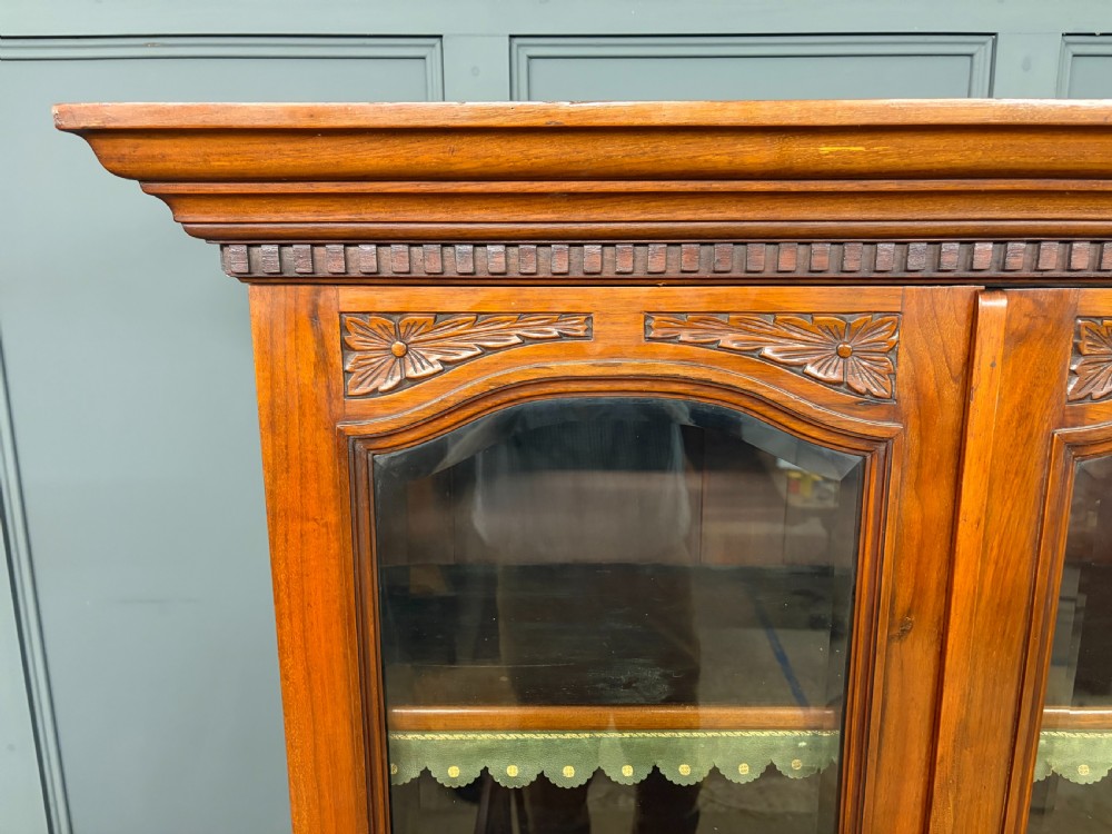 A large Victorian walnut secretaire bookcase featuring three upper glazed doors with arched panels over a central carved writing drawer and lower carved cupboard doors. View XIII