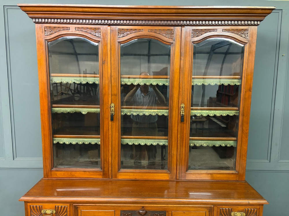 A large Victorian walnut secretaire bookcase featuring three upper glazed doors with arched panels over a central carved writing drawer and lower carved cupboard doors. View XIV