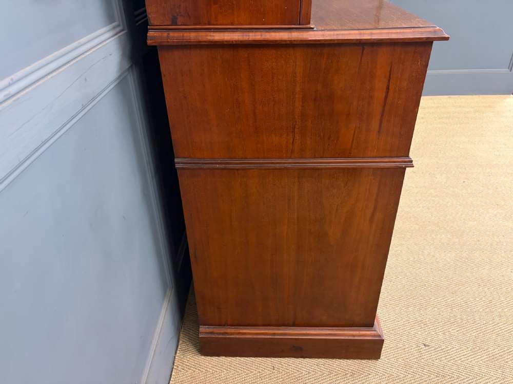 A large Victorian walnut secretaire bookcase featuring three upper glazed doors with arched panels over a central carved writing drawer and lower carved cupboard doors. View XXIII
