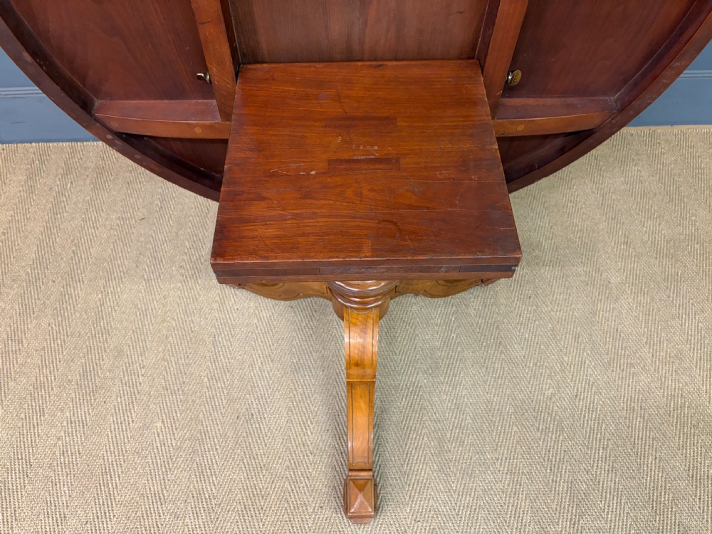 A circular burr walnut centre table featuring a quartered figured veneer top over a turned central pedestal with four carved scroll legs. View XX