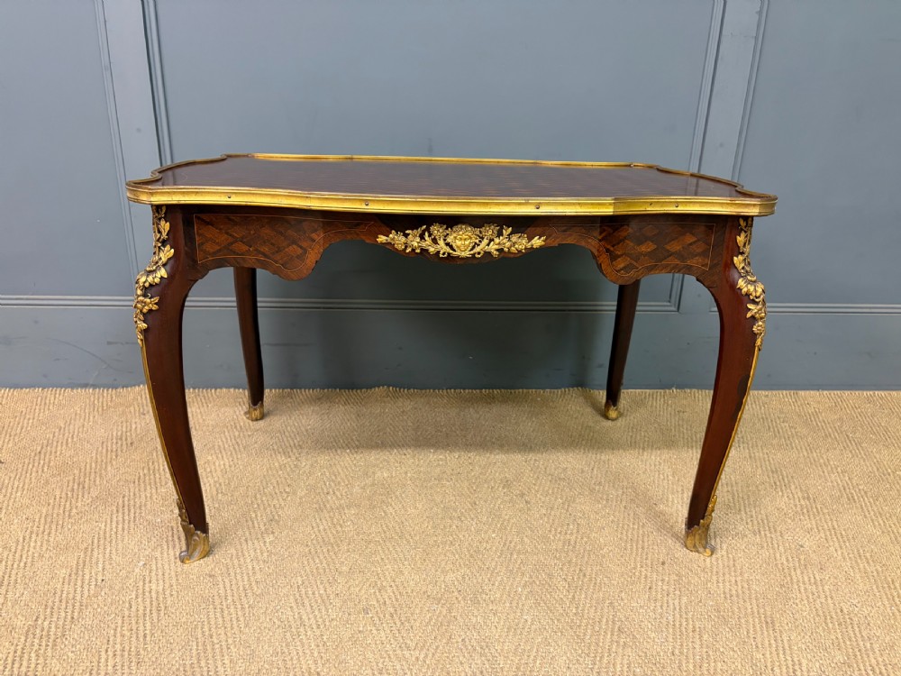 A French Louis XV style low coffee table featuring a serpentine parquetry top, curved cabriole legs, and ornate gilt-bronze mounts. View V