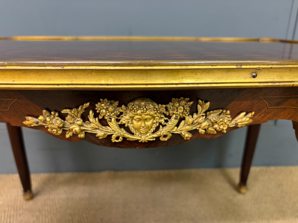 A French Louis XV style low coffee table featuring a serpentine parquetry top, curved cabriole legs, and ornate gilt-bronze mounts. View VII
