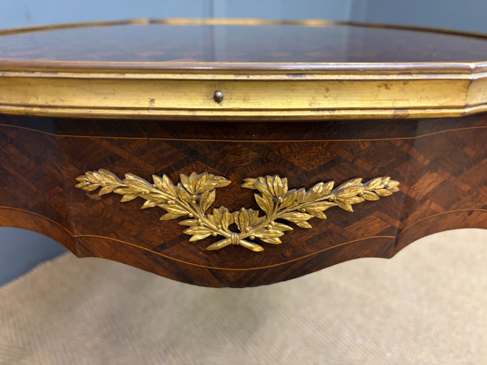 A French Louis XV style low coffee table featuring a serpentine parquetry top, curved cabriole legs, and ornate gilt-bronze mounts. View IX