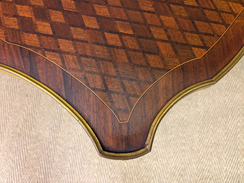 A French Louis XV style low coffee table featuring a serpentine parquetry top, curved cabriole legs, and ornate gilt-bronze mounts. View XII